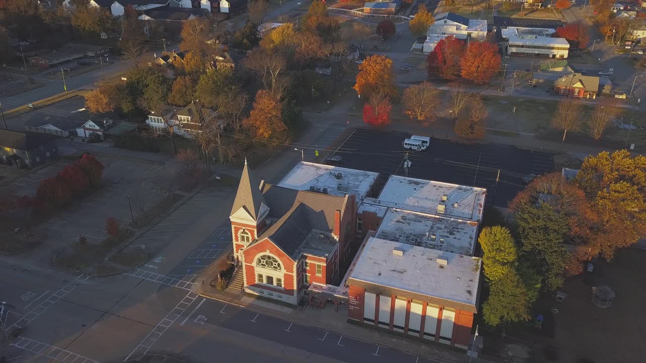 Early morning aerial view of small church in small town during the fall season