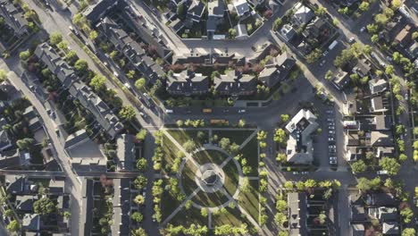 Aerial-sunrise-hold-birds-view-Gazebo-town-square-school-buses-pickup-students-headed-to-school-holding-up-traffic-overlooking-replica-Inverness-town-square-East-North-shadows-cookiecut-homes-SQR4-5