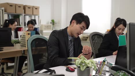 slow motion of sleepy asian man employee becoming full of energy again when he finds it’s time to get off. he closes computer and waves hand to colleagues while leaving office