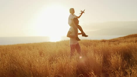 father and son slowly spinning in fields of gold