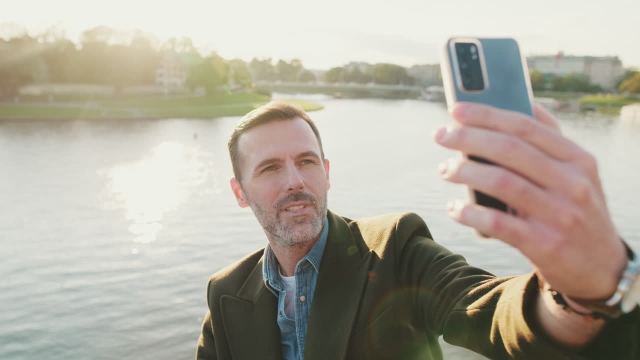 Homem tirando uma selfie com um rio ao fundo