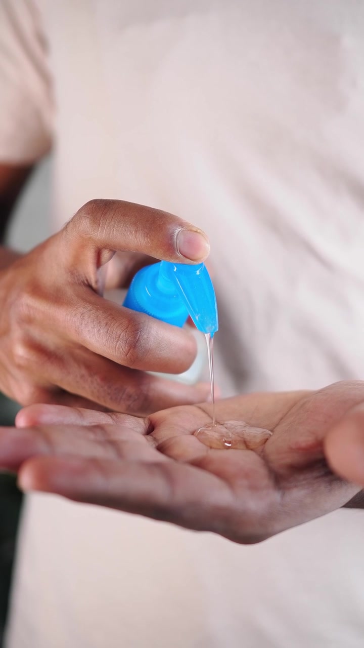 Persona che eroga gel disinfettante per mani nel palmo