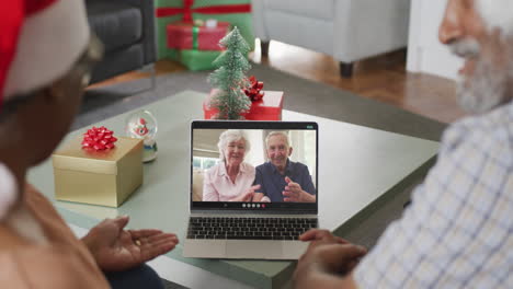 una feliz pareja de ancianos afroamericanos en una llamada de video con amigos de sdenior en navidad