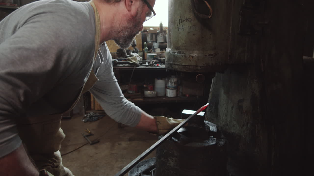 Blacksmith Using Power Hammer in Workshop