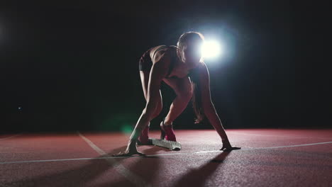 mujer atleta en pantalones cortos negros y una camiseta en zapatillas de deporte están en las almohadillas de carrera en la pista del complejo deportivo y correr en cámara lenta