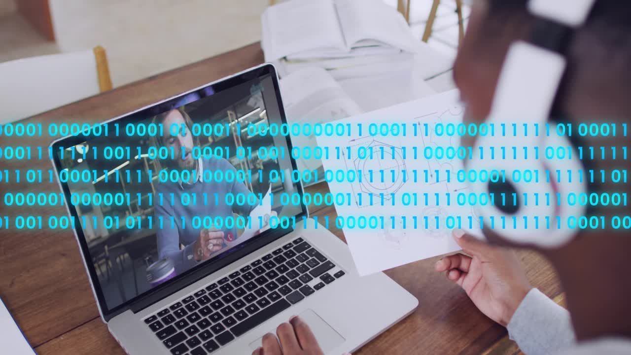 Tech wearing headset reviewing drawing as mentor speaking binary overlay growing across laptop