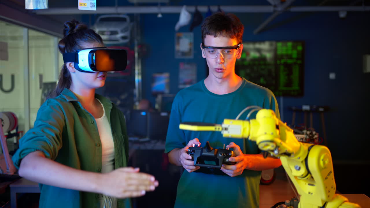 Young engineers with VR virtual reality headset controlling an yellow robotic arm in research laboratory