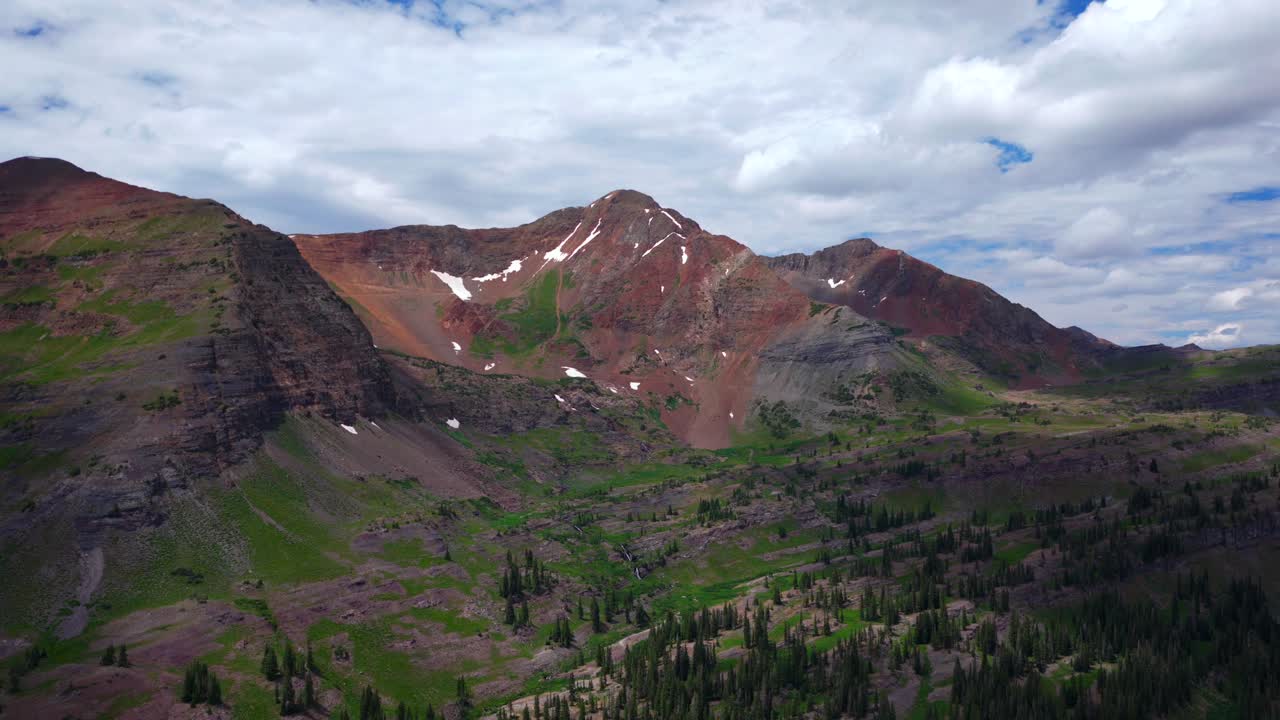 Robinson Basin Ruby Peak Kebler Pass Lake Irwin Trailhead spring summer aerial drone Crested Butte Colorado Gunnison National Forest morning daytime blue sky clouds snow fields pan left motion