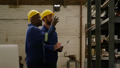 two metalsmith discussing over clipboard 4k