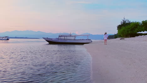 Schöne-Frau,-Die-Im-Morgengrauen-Am-Sandstrand-Spaziert-Und-Zum-Horizont-Blickt