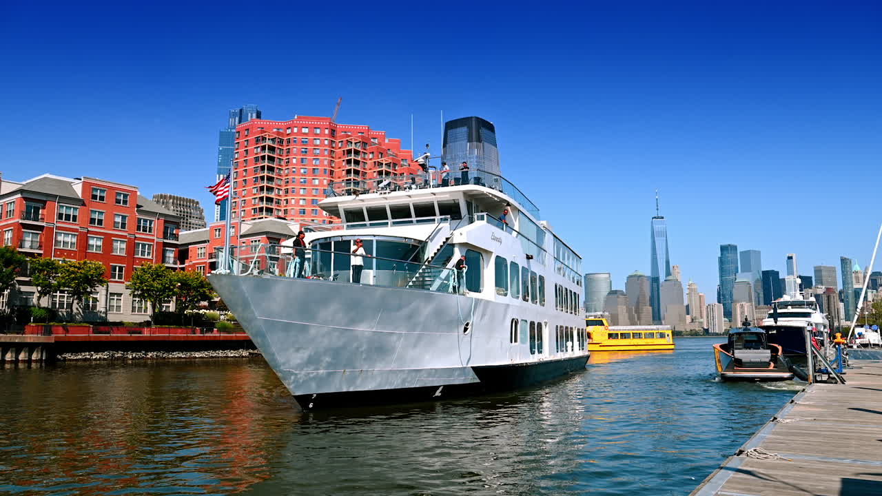 New Jersey, USA, 19 August 2025: Modern cruise boat with people on board approaches the quay in Jersey City. Skyline of Manhattan at backdrop