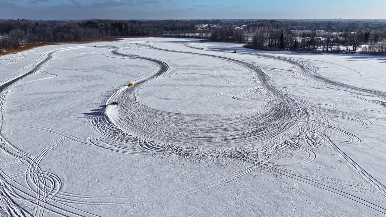 Cars Driving Through An Ice Racing Track On A Frozen Lake. - aerial shot