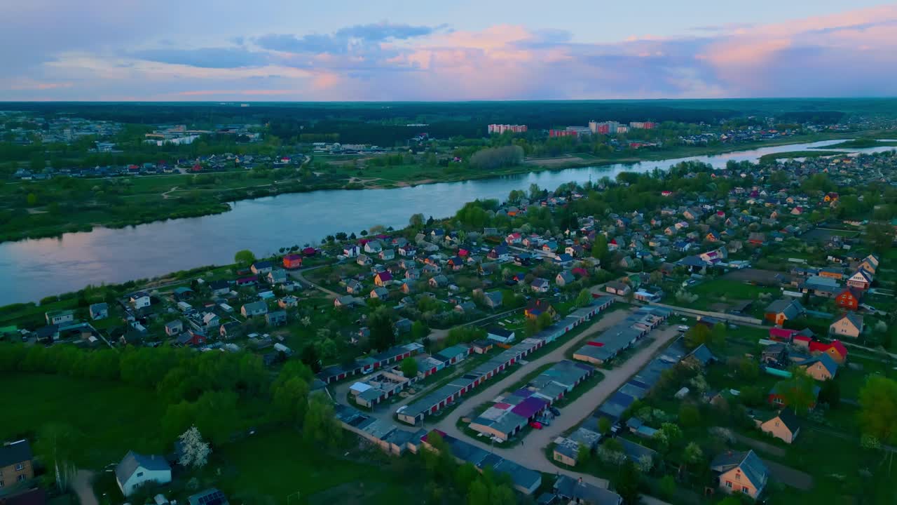 Evening aerial perspective of a suburban grid with houses, trees, and garages near the Daugava River. Location: Daugavpils, Latvia (Daugavpils, Latvija)