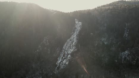 Sunset-over-mountain-forest-and-white-waterfall-of-Valle-Du-Bras-Du-Nord,-Canada