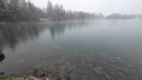 Grandes-Copos-De-Nieve-Caen-Sobre-Un-Lago-Con-Agua-Cristalina-En-Austria