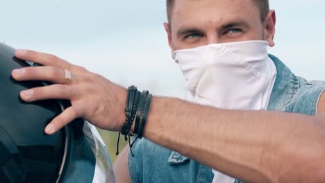 hombre de primer plano en chaleco de denim se quita el casco y la eslinga