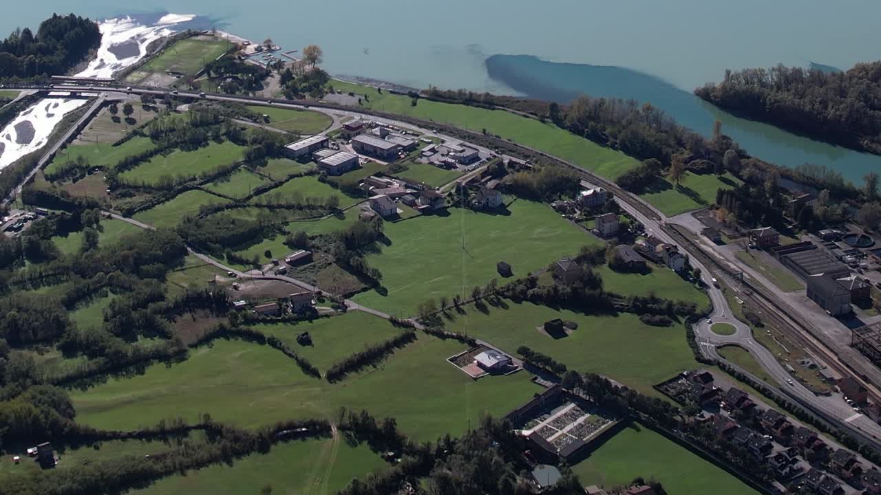 Scenic aerial view of the Italian Alps with lush green fields and water
