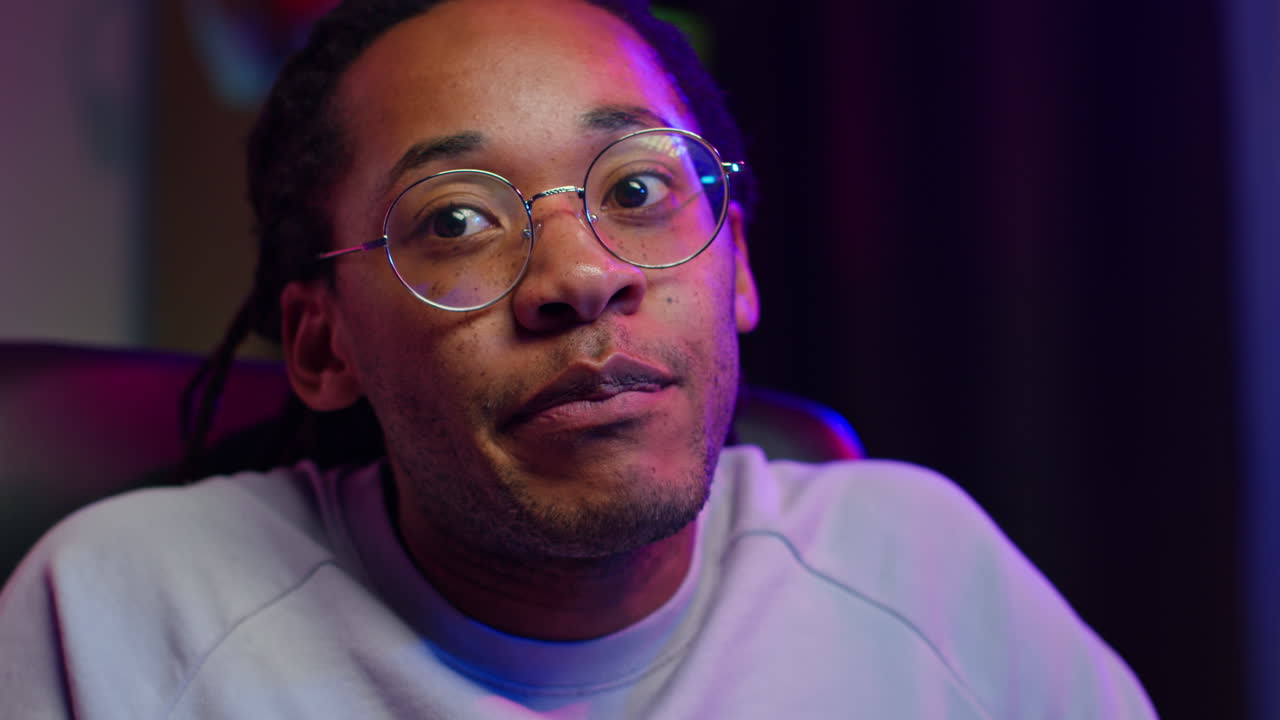 Closeup portrait of a young man with glasses looking seriously at the camera
