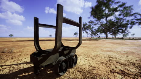 unique rusty cart rests on dry landscape under vast sky during midday