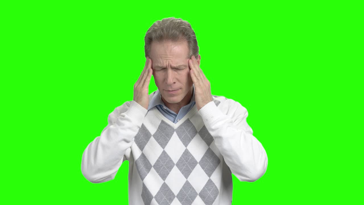 hombre maduro con dolor de cabeza, fondo verde.