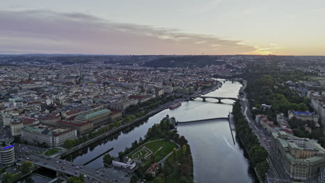 Prag,-Tschechien,-Luftaufnahme-V67-über-Die-Moldau-Und-Die-Insel-Stvanice,-Aufnahme-Der-Stadtlandschaft-Am-Flussufer-Von-Petrska-Ctvrt,-Holesovice-Und-Den-Altstadtvierteln-Bei-Sonnenuntergang-–-Aufgenommen-Mit-Mavic-3-Cine-–-November-2022