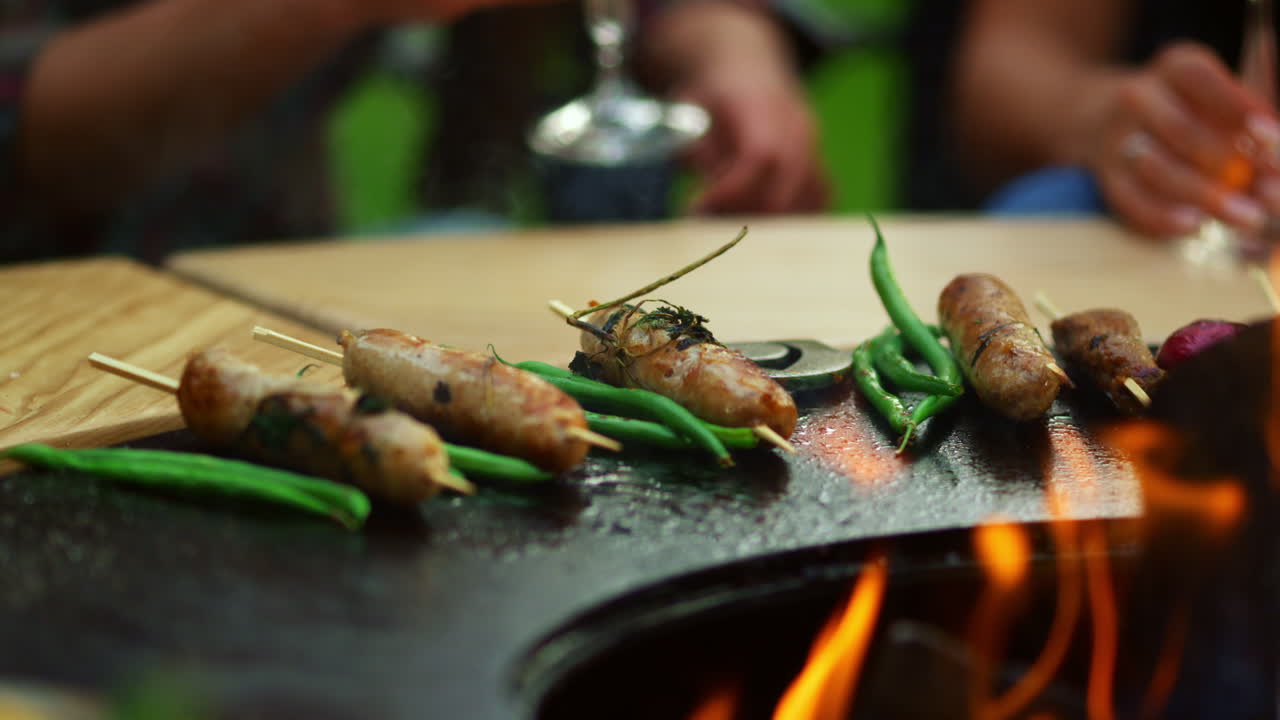 Spuntini che cuociono sulla griglia da barbecue all'aperto. Carne e verdure che si preparano per la festa.