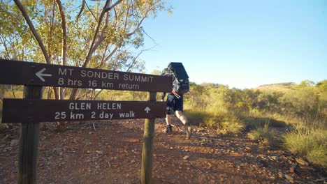 excursionista camina más allá de firmar en larapinta trail, australia central