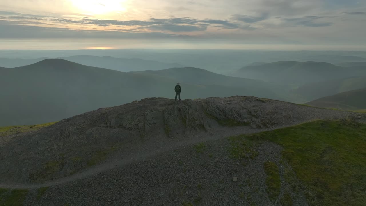 caminante de montaña figura solitaria en la cumbre cayó con órbita revelando valles brumosos y redondeados picos cayó en la hora de oro