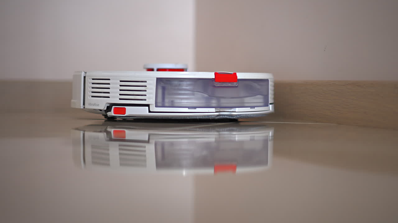 Futuristic white and orange robot vacuum cleaner sweeping the floor