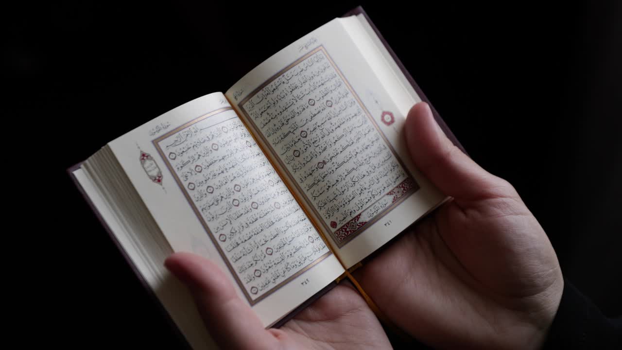 imágenes de una mujer musulmana en hijab leyendo el corán, el disparo se aleja