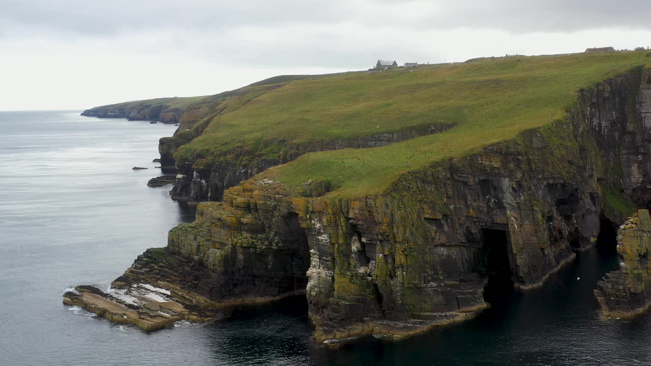 amplia rotación de un dron de whaligoe haven y los acantilados rocosos de 250 pies que dominan el mar del norte en escocia