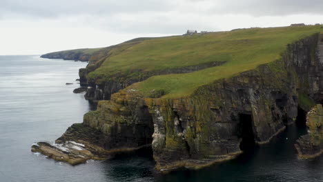 rotating wide drone shot of whaligoe haven and the rocky 250ft cliffs overlooking the north sea in scotland