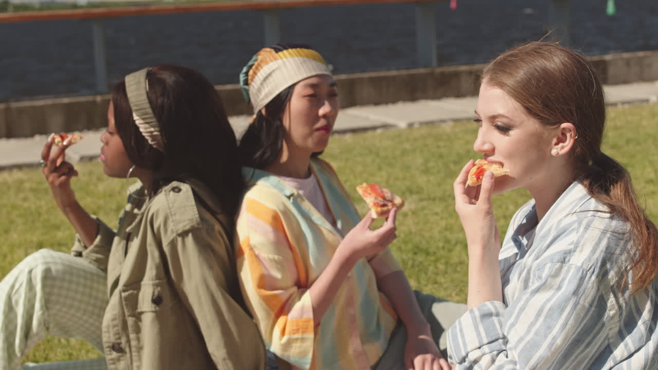 Multiethnic Women Eating Pizza Together at Waterfront