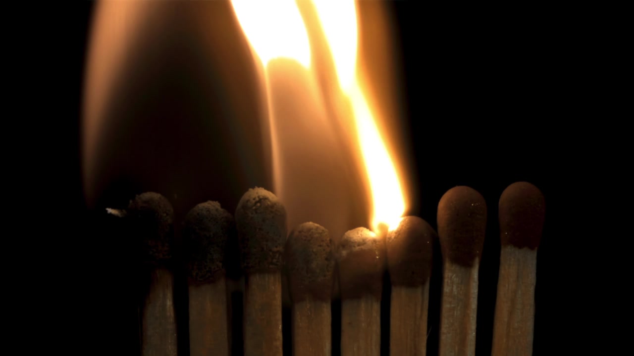 Slow Motion Close-Up of Matches Igniting in a Chain Reaction