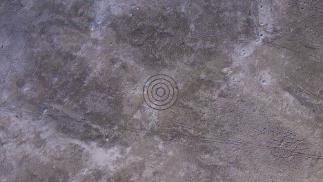 circle target on moon-like rock surface - aerial drone overhead view