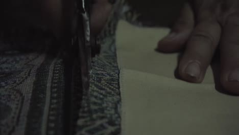 close up look, old lady tailor use scissors to cut traditional thai fabric