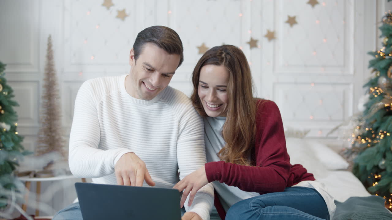 pareja feliz viendo la pantalla de la computadora portátil en una casa de lujo