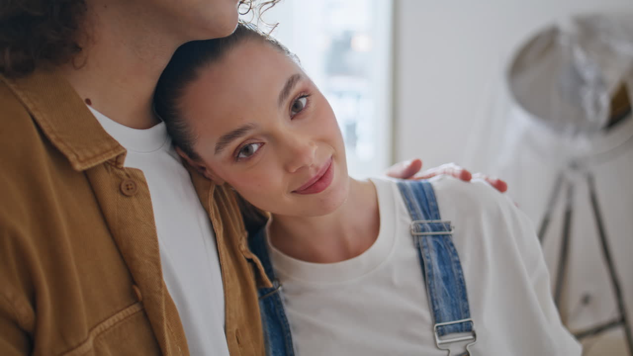 Newlyweds embracing new home feeling happy closeup. Smiling woman leaned husband