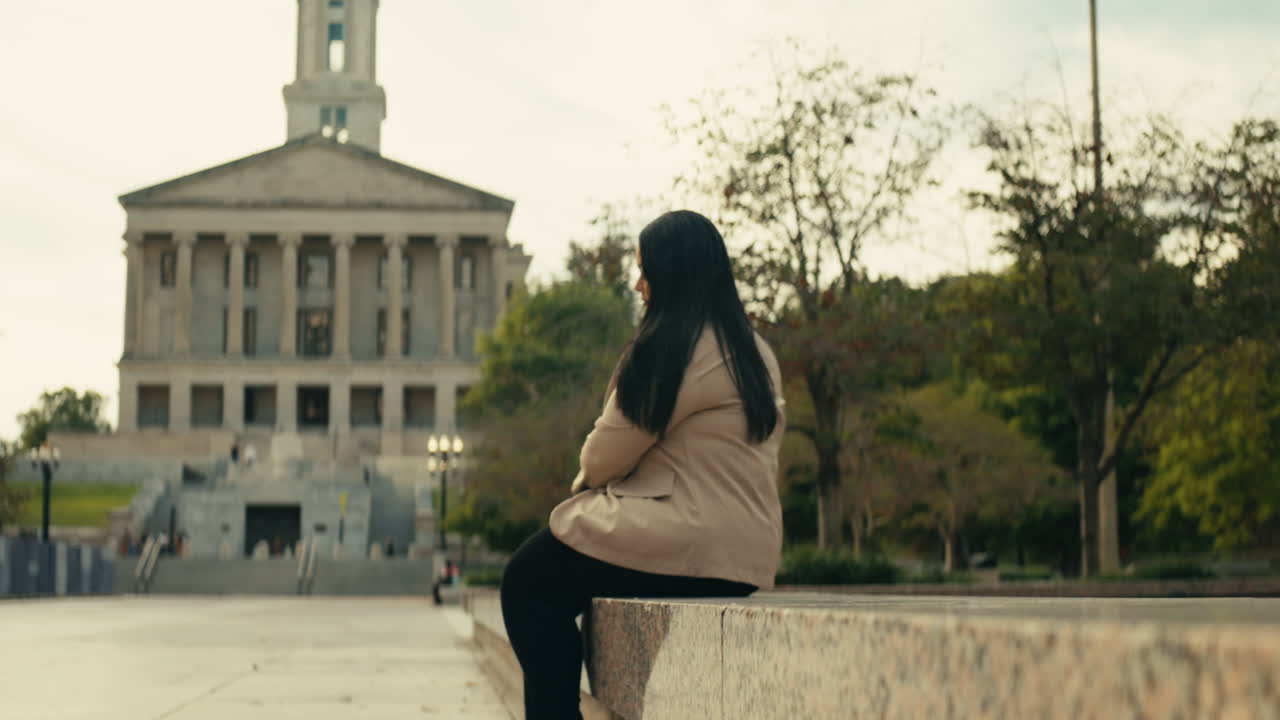 Woman sitting near government building