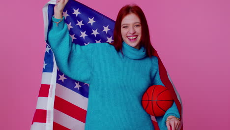 redhead young woman basketball fan holding american usa flag doing winner gesture, dancing alone