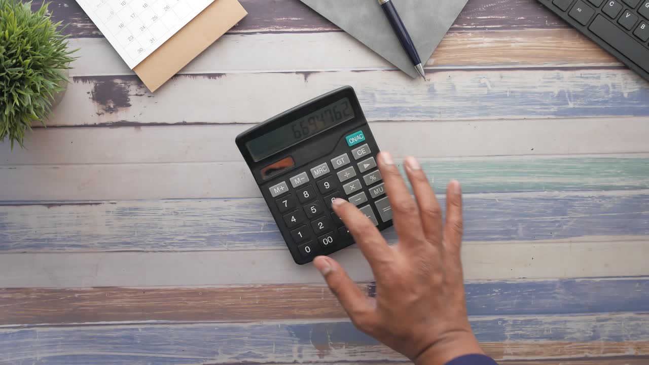 vista desde arriba de la mano del hombre utilizando la calculadora,