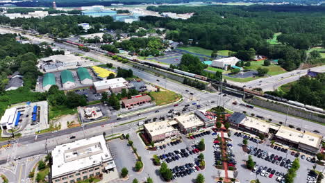 Vista-Aérea-Del-Tráfico-Por-Carretera-Y-Ferrocarril-En-Los-Suburbios