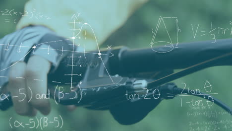 ecuaciones matemáticas y diagramas contra una persona que sostiene el manillar de su bicicleta