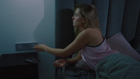 woman turning off lights and going to sleep