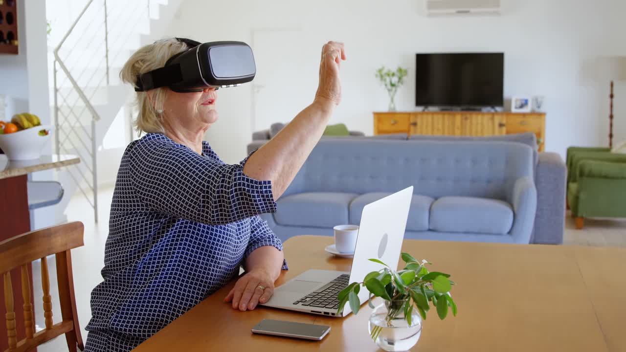 Senior woman using virtual reality headset at home 4k