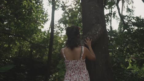 Una-Hermosa-Niña-India-Moviendo-Su-Palma-En-La-Superficie-De-Un-Tallo-De-árbol-En-Un-Día-En-El-Bosque