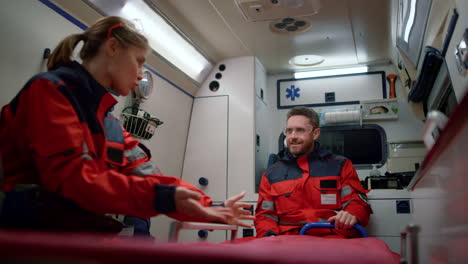 team of paramedics driving on emergency call inside ambulance car