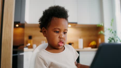 baby girl using a tablet in kitchen