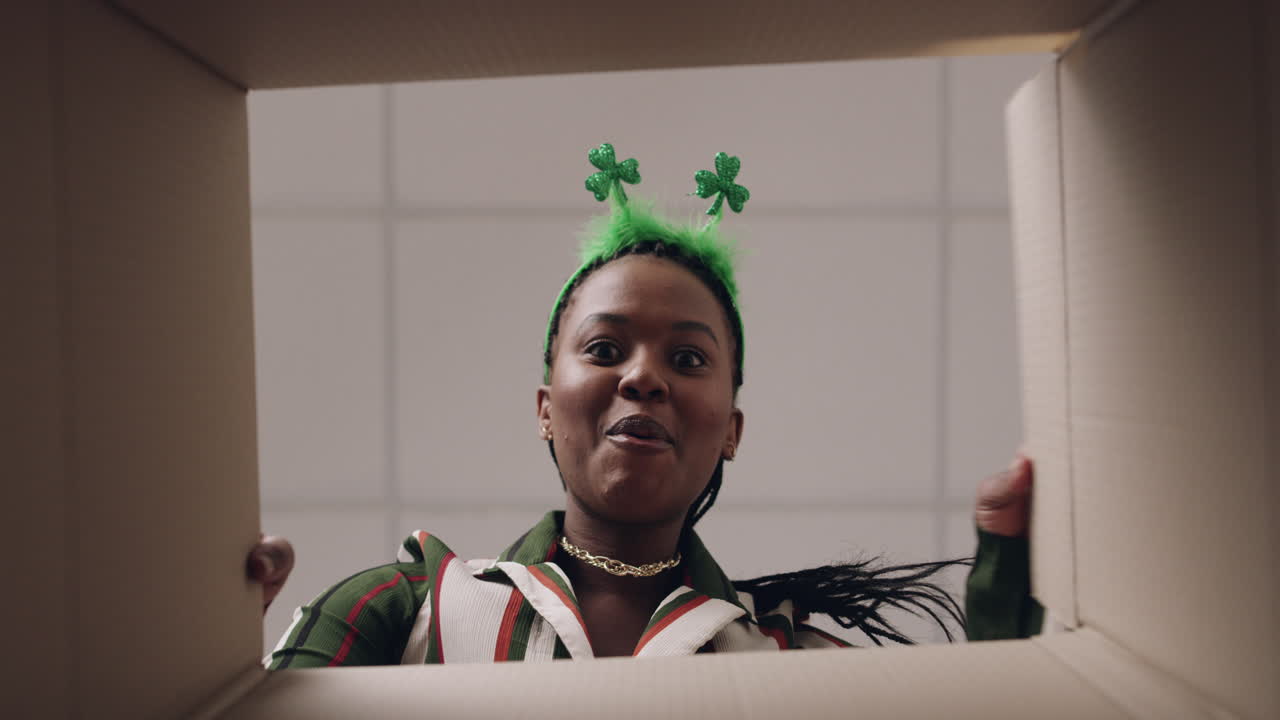 여자 는 기쁜 마음 으로 선물 상자 를 열고 있다