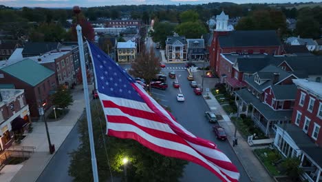 american flag waving proudly in town square at dusk